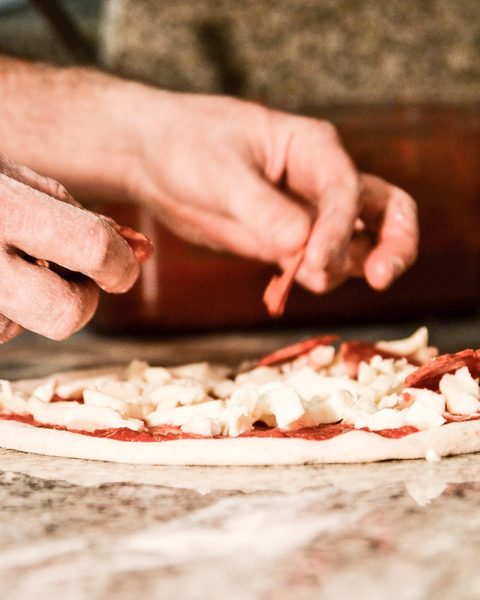 Il salame appoggiato sulla pizza, fetta per fetta