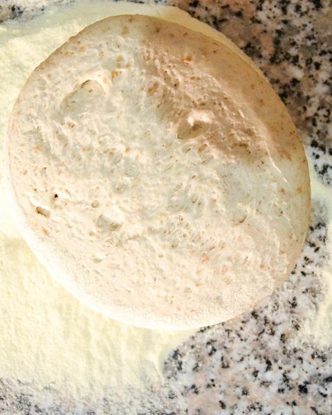 Un disco di pasta appena aperto sul granito infarinato